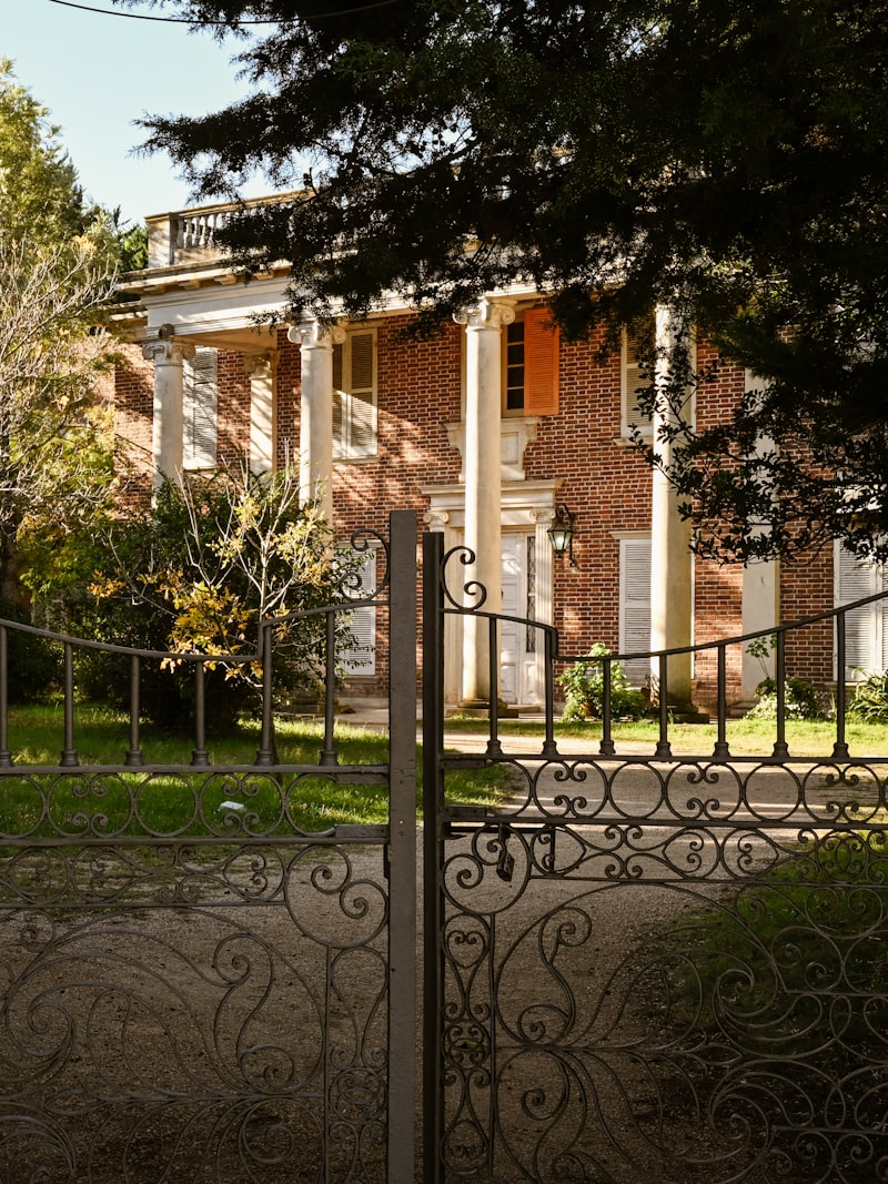 Stately mansion behind an ornate iron gate